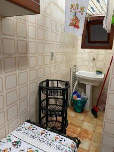 baño con 2 cestas, lavamanos y aseo en Apartamento para Temporada Ubatuba, en Ubatuba
