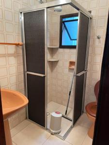 a shower with a glass door in a bathroom at Apartamento para Temporada Ubatuba in Ubatuba