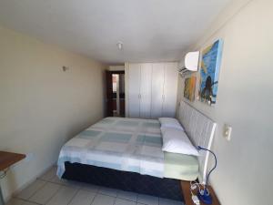 a small bedroom with a bed and a lamp at Apartamento 403 - Largo de Tambau in João Pessoa