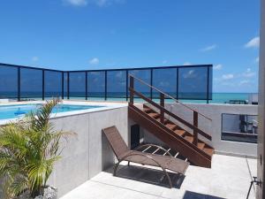 a balcony with a chair next to a swimming pool at Apartamento 403 - Largo de Tambau in João Pessoa