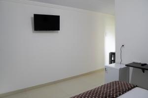 um quarto branco com uma televisão na parede em Refúgio da Montanha - Cascata - Lumiar em Lumiar