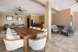 una sala da pranzo con tavolo e sedie in legno di Barong Luxury Home overlooking Cairns Unrivalled privacy and location a Cairns