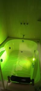 a green tub in a bathroom with a green light at Maloka lago de bachue in Villa de Leyva