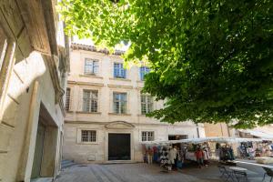 um edifício antigo com um mercado em frente em Élégant T3 Le Petit Palais Avignon em Avignon