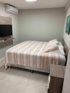 Dormitorio pequeño con cama y TV en Apto completo para curtir uma boa praia e relaxar, en Camassari