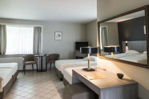 um quarto de hotel com duas camas e um espelho em Hotel In den Bonten Os em Rijmenam