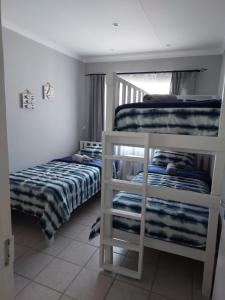 a bedroom with two bunk beds and a window at The Dutch Corner house in Langebaan