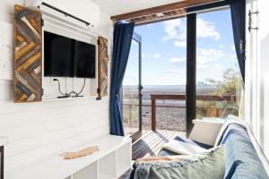 a living room with a tv and a window at Two Tiny Homes on the Farm! in Tulare