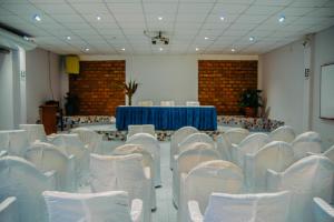 Habitación con sillas blancas y mesa con mantel azul. en Hotel Cielo Tarapoto, en Tarapoto 99 fotos más