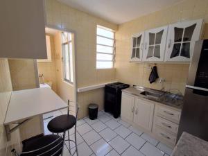 a small kitchen with a sink and a stove at Charmoso apartamento próximo ao Consulado EUA in Porto Alegre