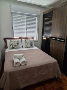 1 dormitorio con 1 cama con 2 toallas en Charmoso apartamento próximo ao Consulado EUA, en Porto Alegre