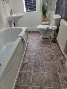 a bathroom with a tub and a toilet and a sink at 1 bedroom flat in Neepsend