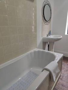 a bathroom with a bath tub and a sink at 1 bedroom flat in Neepsend