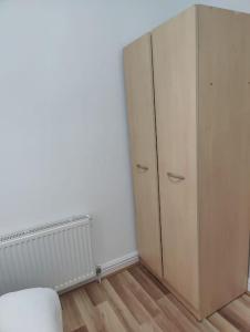 a white cabinet in a room with a wooden floor at 1 bedroom flat in Neepsend