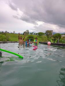 un groupe de personnes jouant dans une piscine dans l'établissement Finca Pradera Real, à Circasia