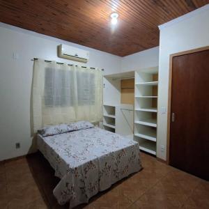 um quarto com uma cama e um tecto de madeira em Hostel Casa Uniao em Maracaju