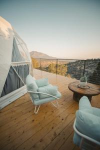 Un balcón con una silla, una mesa y vistas. en Zia Geo Dome At El Mistico Ranch, Glamping, en Nogal