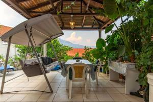 stół i krzesła pod parasolem na patio w obiekcie Apartments by the sea Korcula - 9321 w Korčuli