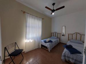 - une chambre avec 2 lits et un ventilateur de plafond dans l'établissement Casa de Temporada - São Sebastião - Praia Barequeçaba - 500m da praia, à São Sebastião