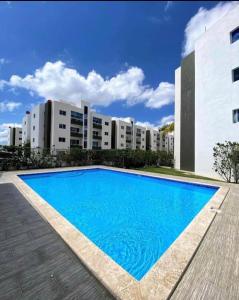 a large blue swimming pool in front of a building at Joel Arturo Residences in Licey al Medio