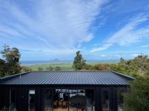 a house with a black roof with a view at Tranquil Conservation RETREAT in Matata