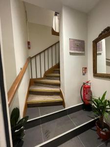 eine Treppe in einem Gebäude mit einem Feuerlöscher in der Unterkunft Hôtel De La Herse d'Or in Paris