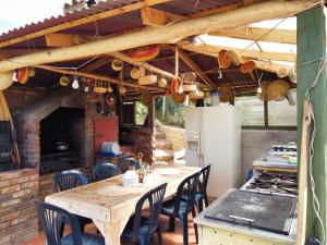 an outdoor kitchen with a wooden table and chairs at Cabaña Isla Dorada in Guatavita