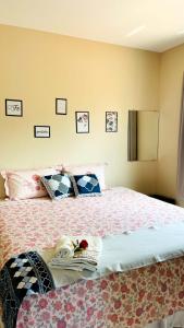 Schlafzimmer mit einem Bett mit Kissen und Bildern an der Wand in der Unterkunft Pousada OPA - O Paraíso é Aqui Abrolhos in Caravelas