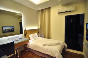 マラッカにあるMIO BOUTIQUE Hotelのベッドと机があるホテルの部屋