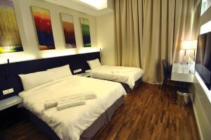 a hotel room with two beds with towels on them at MIO BOUTIQUE Hotel in Melaka