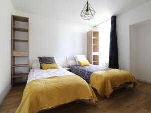 1 dormitorio con 2 camas con sábanas amarillas en Gîte Bouchemaine, 3 pièces, 4 personnes - FR-1-622-15 en Bouchemaine