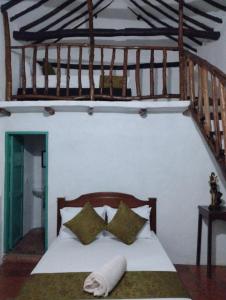 una camera con letto bianco e testiera in legno di HOSPEDAJE CASA GRANDE ARBOLITO a Barichara