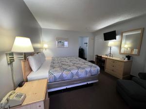 Pokój hotelowy z łóżkiem i biurkiem w obiekcie Regency Inn w mieście Dodge City