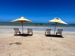 聖米格爾－杜斯米拉格里斯的住宿－Kanui Casa Maré 107，海滩上的两把椅子和两把遮阳伞