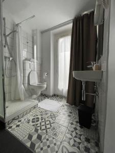 La salle de bains blanche est pourvue d'un lavabo et de toilettes. dans l'établissement Hôtel De La Herse d'Or, à Paris