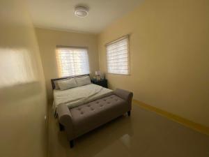 1 dormitorio con cama y sofá en DenLab Family House en Iloilo