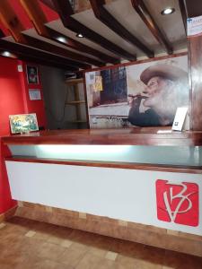 a counter in a restaurant with a picture of a man at Hotel Buenavista - BV Hoteles in La Falda