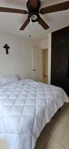 1 dormitorio con 1 cama blanca y ventilador de techo en casa violeta norte, en Tuxtla Gutiérrez