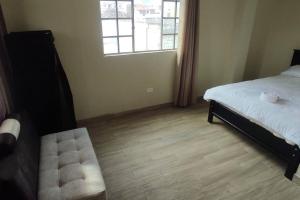sypialnia z łóżkiem, oknem i drewnianą podłogą w obiekcie 2 Cuarto independiente en Ambato w mieście Ambato