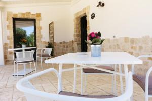uma mesa branca e cadeiras num quarto em Residence Spadalunga em San Michele Salentino