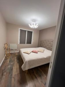1 dormitorio con cama y lámpara de araña en Lusyana en Janzé