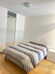 Acogedor y espacioso apartamento في ليما: غرفة نوم بسرير في غرفة بيضاء