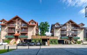 a large building with cars parked in front of it at Willa Szafir z WIDOKIEM NA ZALEW in Krynica Morska