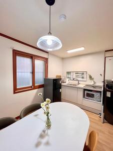 een keuken met een witte tafel met een vaas met bloemen erop bij [New!] 3BR & 2Bath for big group in Seoul