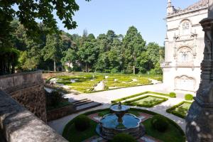 a garden with a fountain and a clock tower at Palace Hotel do Bussaco in Luso