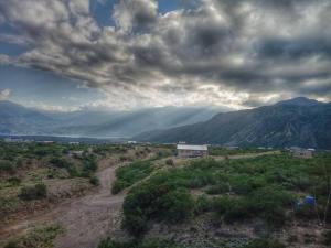 a dirt road in the middle of a field with mountains at Cabañas IsaMart in Potrerillos