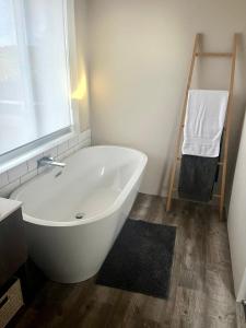 a white bath tub in a bathroom with a window at Whalestail in Witsand +32 photos