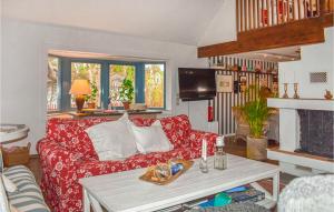 - un salon avec un canapé rouge et une cheminée dans l'établissement Lovely Home In Hllviken With Kitchen, à Höllviken