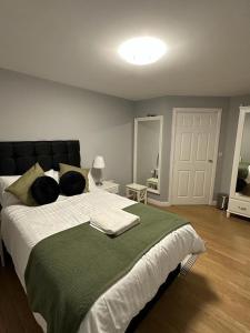 a bedroom with a large bed with a green blanket at Newly Refurbished 2 Bedroom Apartment Weston Super Mare in Worle