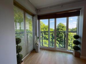 a room with windows with blinds and potted plants at Contemporary, Stylish Apartment in Weston in Worle